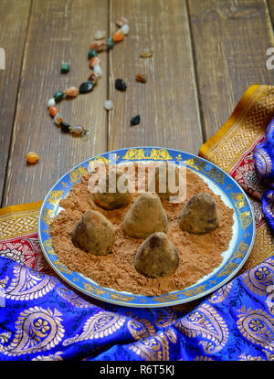 Vegan Homemade Candies in cocoa powder on Ethnic background. Stock Photo