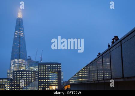 The Shard skyscraper and pedestrians on London Bridge on a dark winter's afternoon, on 23rd November 2018, in London, England. Stock Photo