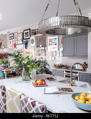 Downton chandelier above reconfigured kitchen with upcycled seating Stock Photo