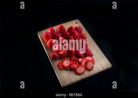 Strawberries on cutting board with black background for marketing purposes Stock Photo