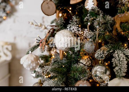 Merry Christmas and happy new year concept, Closeup of white,silver bauble hanging from a decorated tree with bokeh, Xmas holiday.Christmas decorations, Christmas tree, gifts, new year.Scandinavian style Stock Photo