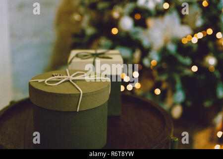 Festive Gifts with Boxes, Coniferous, Basket on blurred christmas tree Background. Christmas Presents Toned in Vintage Style.Christmas and New Year Decoration isolated on white background. Border art design with holiday baubles. Stock Photo