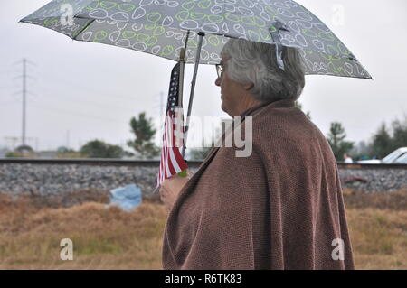 Houston, USA. 6th Dec, 2018. A woman waits for the train carrying the remains of late former U.S. President George H.W. Bush in Houston, Texas, the United States, on Dec. 6, 2018. Bush's remains were taken by the train on Thursday from Houston to the burial site behind the George H.W. Bush Presidential Library and Museum at Texas A&M University. George H.W. Bush, the 41st president of the United States, has died on Nov. 30 at the age of 94. Credit: Liu Liwei/Xinhua/Alamy Live News Stock Photo