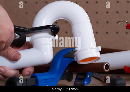 plumber at work on his workbench to fit pipes Stock Photo