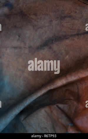 Abstract closeup detail of a weathered tarpaulin with colors Stock Photo