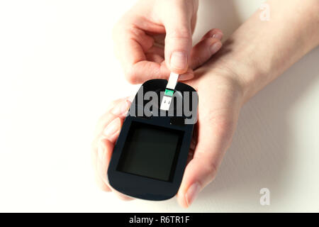 Diabetes checking blood sugar level. Woman using lancelet and glucometer at home Stock Photo