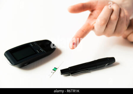 Diabetes checking blood sugar level. Woman using lancelet and glucometer at home Stock Photo
