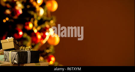 Christmas decorations hanging on wall against copy space with a christmas tree Stock Photo