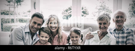 Multi generation family sitting on sofa in living room Stock Photo