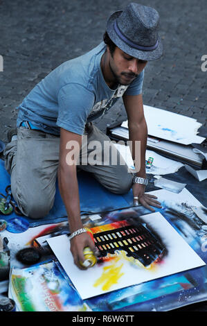 Street male artist creates images of the Roman architecture by using and mixing  aerosol paint in Piazza Navona, a popular square among artists, Rome Stock Photo