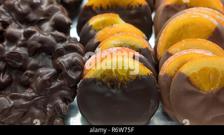 Chocolate covered candied orange slices displayed at the baker shop, prepared for winter holidays, caramelized orange slices dipped in chocolate Stock Photo