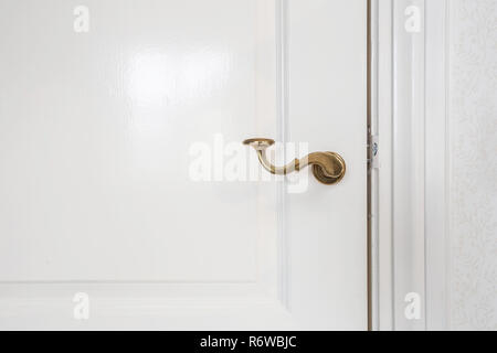 Wooden white door, with gold door handle close-up Stock Photo