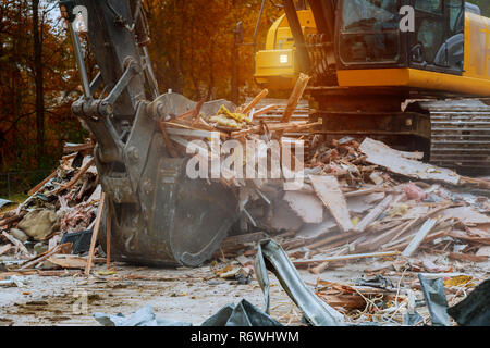 old house being demolished by a large backhoe Stock Photo