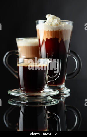 Various coffee drinks on black reflective background. Stock Photo