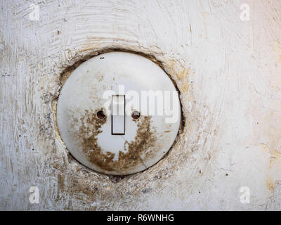 Old dirty light switch on white wall Stock Photo