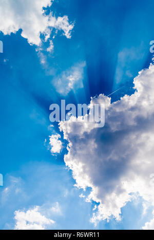 White clouds and sunrays on blue sky Stock Photo