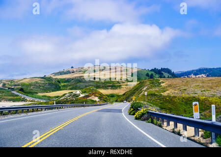 Driving on the scenic Highway 1 (Cabrillo Highway) on the Pacific Ocean coastline close to Davenport, Santa Cruz mountains visible in the background;  Stock Photo