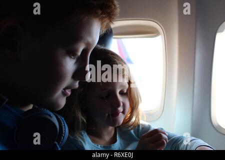 Caucasian brother and sister playing together on a plane Stock Photo