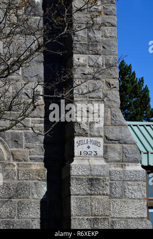 A corner stone block in the Stella Maris Roman Cathloic church telling the building date and a medieval, cross in Saint John New Brunswick Canada Stock Photo