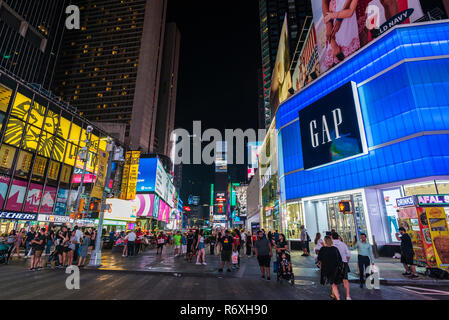 New York City, USA - July 30, 2018: Times Square at night with people around and large advertising screens in Manhattan in New York City, USA Stock Photo