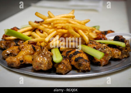 Plate of Flame Broiled Fried Chicken Wings with French Fries and Celery and Ranch Dressing - Room for Copy Stock Photo