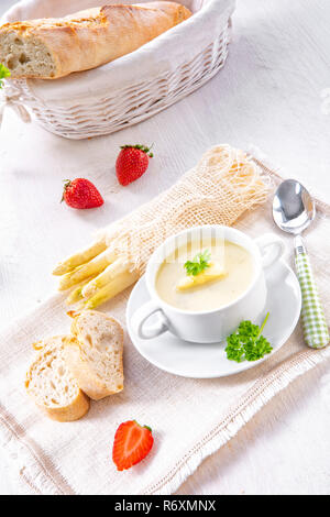 asparagus cream soup with capers and fresh baguette Stock Photo