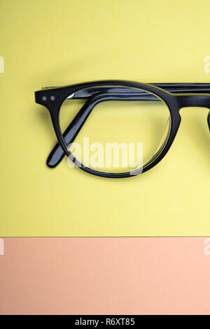 black glasses on yellow and orange ground Stock Photo