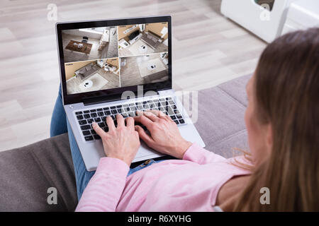 Woman Monitoring Home Security Cameras On Laptop Stock Photo