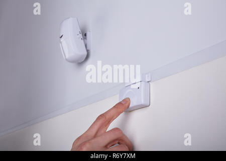Person Pressing Security System Door Sensor Stock Photo