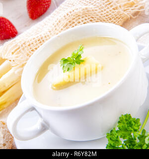 asparagus cream soup with capers and fresh baguette Stock Photo