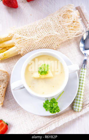 asparagus cream soup with capers and fresh baguette Stock Photo