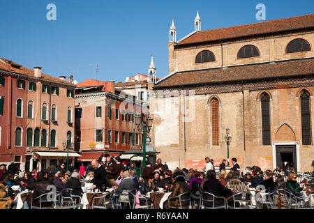 Crowds relaxing at outdoor cafes in Campo Santo Stefano during Carnivale 2011 in Venice Italy Stock Photo