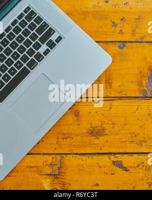 Laptop computer on office table background. Top view of minicomputer on wooden board. Stock Photo
