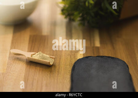 Ginger spice powder and herbs on a wooden spoon. Ingredients for cooking and seasoning. Stock Photo