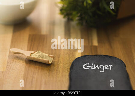 Ginger spice powder and herbs on a wooden spoon. Ingredients for cooking and seasoning. Stock Photo