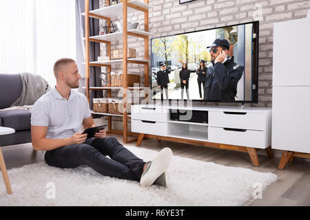 Man Streaming Television Channel Through Wireless Connection On Digital Tablet Stock Photo