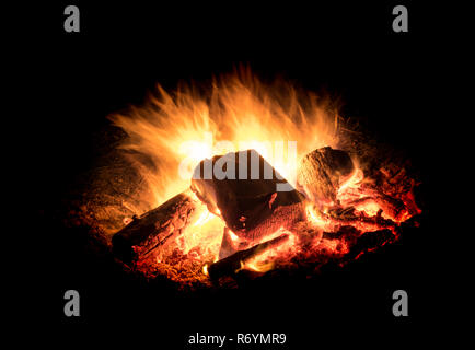 bright burning fire with embers in front of black background Stock Photo