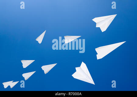 White paper airplanes against the blue sky. The symbol of freedom and privacy on the Internet. Stock Photo