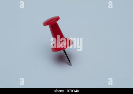 Single red pushpin isolated on white papers Stock Photo