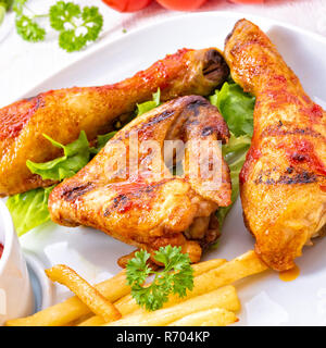 grilled chicken wings,legs,chips and vegetables Stock Photo
