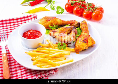 grilled chicken wings,legs,chips and vegetables Stock Photo