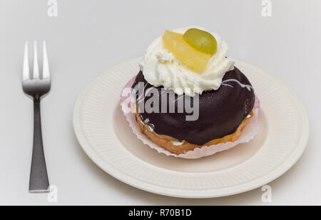 Typical dutch pastry Moorkop, served on a white plate Stock Photo