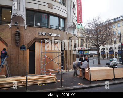 07 December 2018, France (France), Paris: Craftsmen secure a bank branch near the Opera House with wooden panels against the expected protests in Paris. Due to the ongoing protests, security precautions are being taken in downtown Paris. Photo: Christian Böhmer/dpa Stock Photo