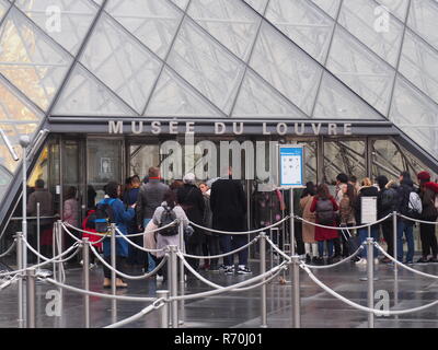 07 December 2018, France (France), Paris: Only a few visitors stand in front of the closed pyramid in the courtyard of the Louvre Museum, which houses Leonardo da Vinci's Mona-Lisa. The world-famous museum will remain closed on Saturday because of the protests in the capital. Photo: Christian Böhmer/dpa Stock Photo