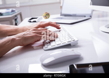 Businessperson Typing On Computer Keyboard Stock Photo