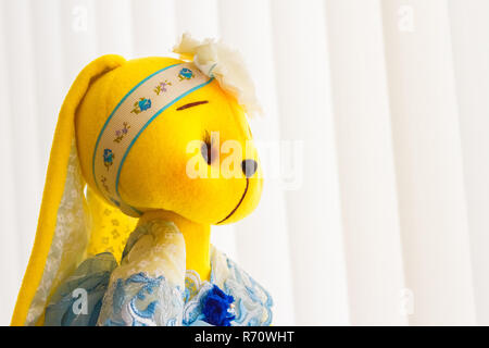 Handmade yellow doll bunny close-up in blue dress Stock Photo