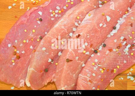 Pork chops with spices on a cutting board. Slices of pork steaks. Pork chops ready to fry. Selective focus Stock Photo