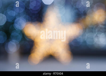 Blurred Christmas background. Gold star and blue blurry lighting in a cafe or showcase Stock Photo
