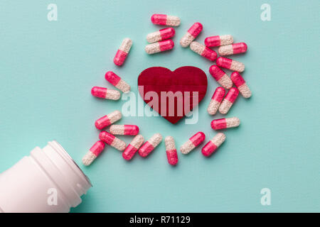 Red heart with pills on table Stock Photo