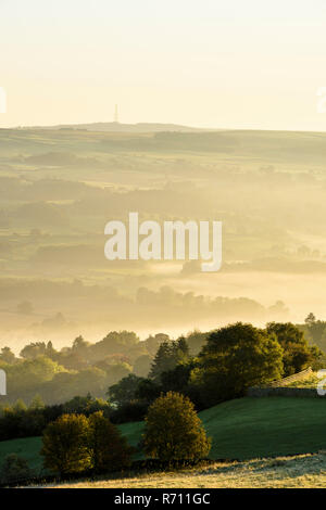 Long-distance, foggy, early morning view over scenic rural Wharfedale, the valley shrouded in mist or fog - near Ilkley, West Yorkshire, England, UK. Stock Photo